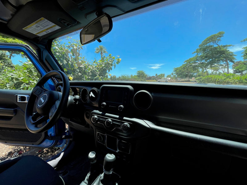 View from a blue Jeep's interior: dashboard, steering wheel, and sunny tropical scene outside. Your adventure beyond a typical rv rental. — photo 10