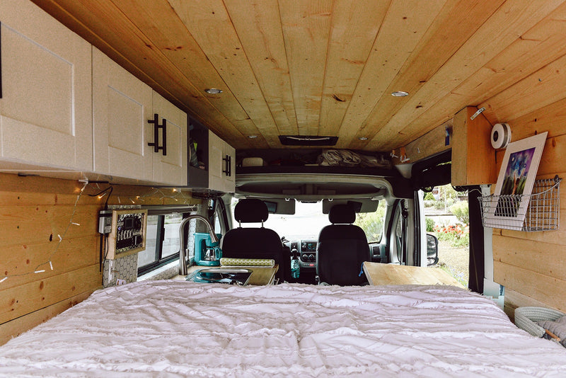  and cabin/appliance switches. Campervan power.|Compact rv rental van interior showcasing a cozy bed — photo 16