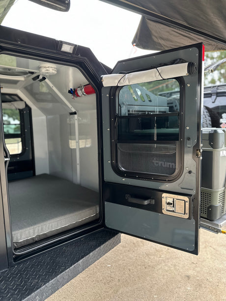 RV rental: Step inside this overland camper with a comfy bed, fire safety, and an accessible outdoor fridge.