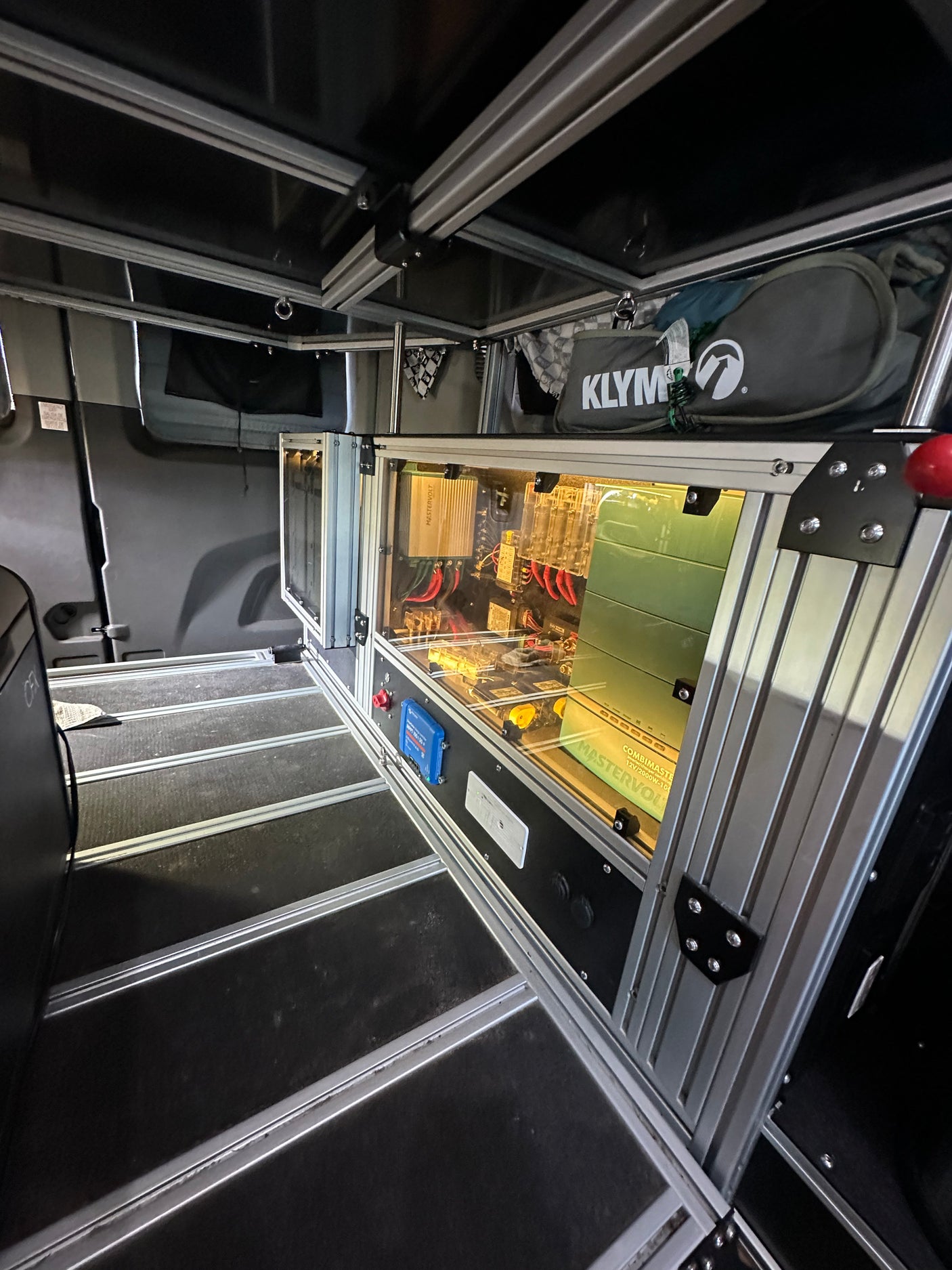 Inside an RV rental: modular build, visible power system with Mastervolt inverter, Victron solar controller, and storage bags.