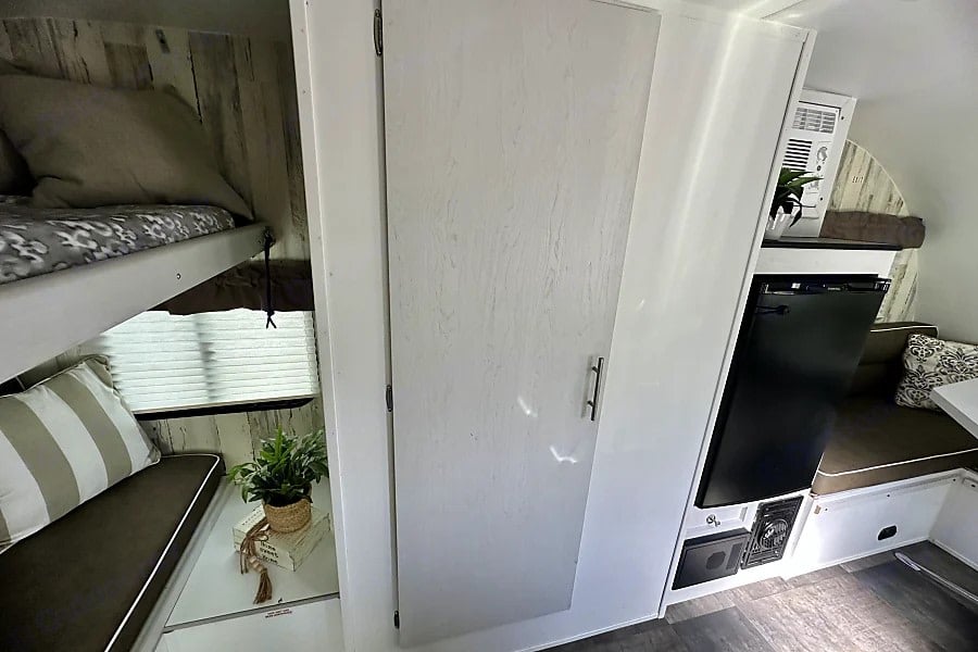  and bunk beds. Features a floral centerpiece on the table.|This RV rental offers a well-equipped interior with a fridge — photo 4
