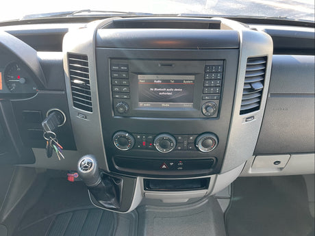 RV rental dashboard showing infotainment system with Bluetooth error, climate controls, gear shifter, and keys.