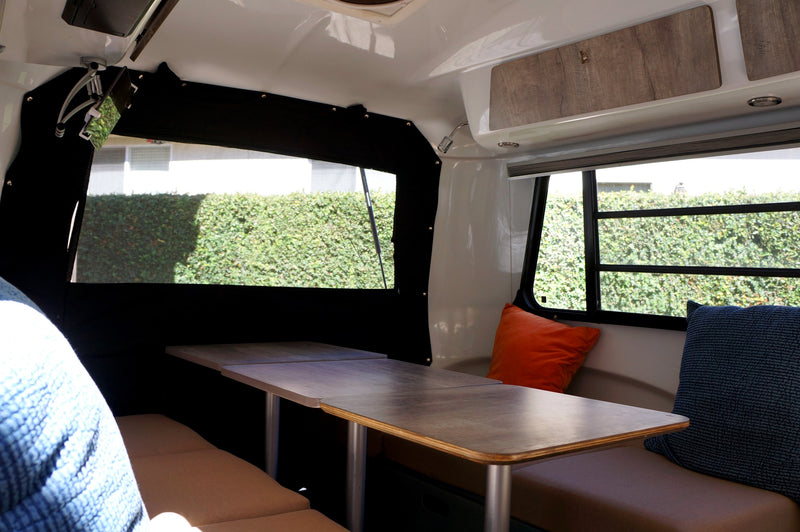 Modern rv rental interior: bright dining area with comfy benches, large windows, & scenic views. Ideal for travel. — photo 3
