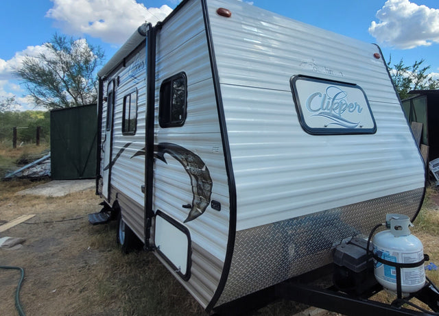  lit by an overhead fixture.|RV rental kitchenette features microwave