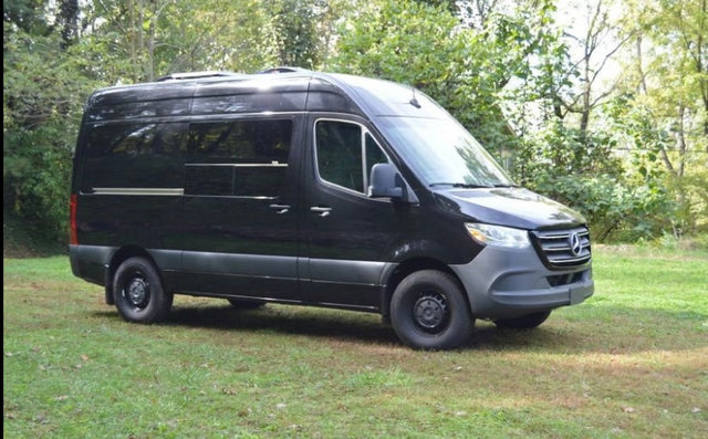 Black Mercedes-Benz Sprinter van, converted for rv rental, parked on grass. Ready for adventure travel.