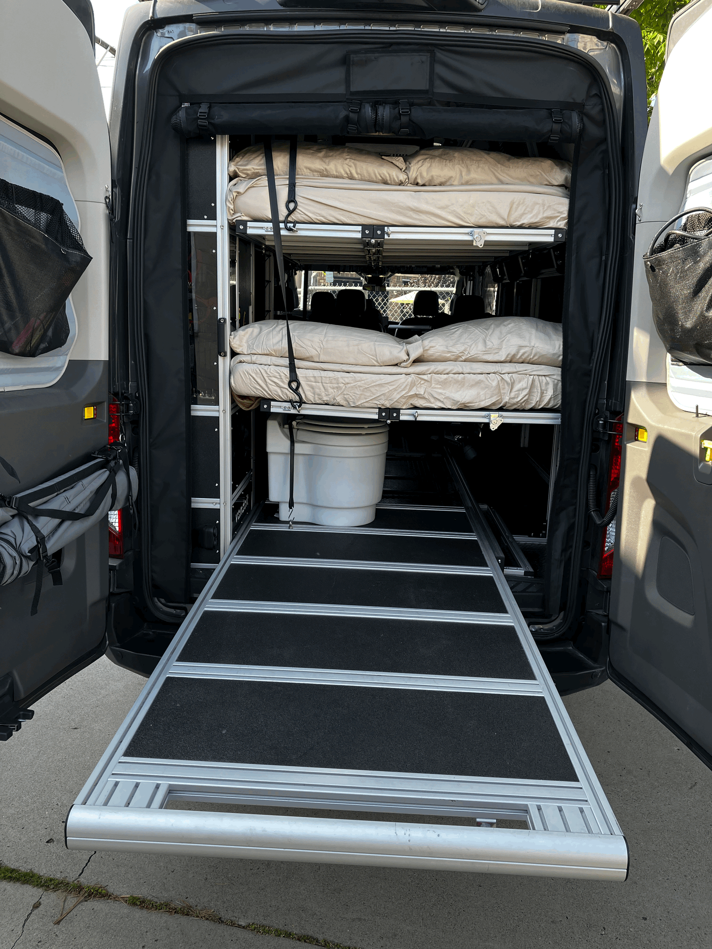Explore this RV rental's versatile camper van interior: modular beds, portable toilet, and handy pull-out ramp.