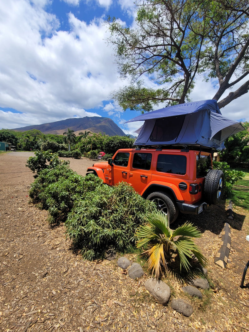  ideal Hawaii RV rental for your outdoor camping adventure.|An orange Jeep Wrangler with an open blue rooftop tent — photo 20