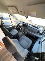 Spacious front cabin of an RV rental, showing driver and passenger seats, dashboard, and steering wheel, ready for travel.