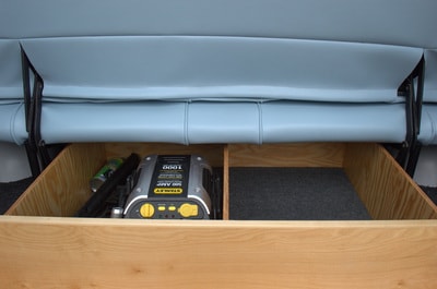 RV rental: Organized under-seat storage in an RV, revealing a Stanley 1000 Amp jump starter and roadside essentials. — photo 14