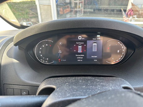 Digital dashboard of an **rv rental** showing a low **tire pressure** warning (70 PSI), an open door, 0 MPH, and 19091 miles.