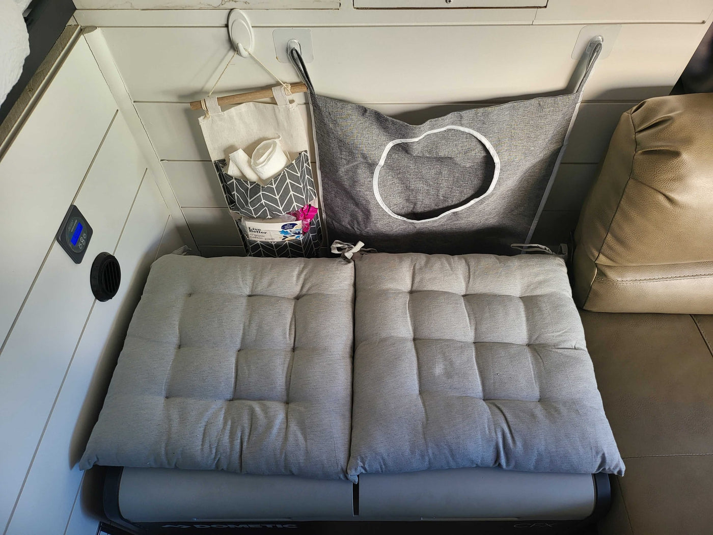 Cozy RV rental interior with Dometic cooler, comfy seating, and hanging organizers for essentials. — photo 8