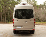Rear view of a beige Mercedes-Benz Sprinter Roadtrek camper van, parked outdoors, ready for your rv rental adventure.
