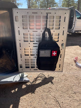 For your RV rental adventure, a first aid kit is organized on an overland vehicle's metal rear panel.
