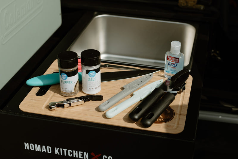 Perfect compact kitchen for your RV rental. Features a sink, cutting board, spices, utensils, and Purell for convenient outdoor cooking. — photo 18
