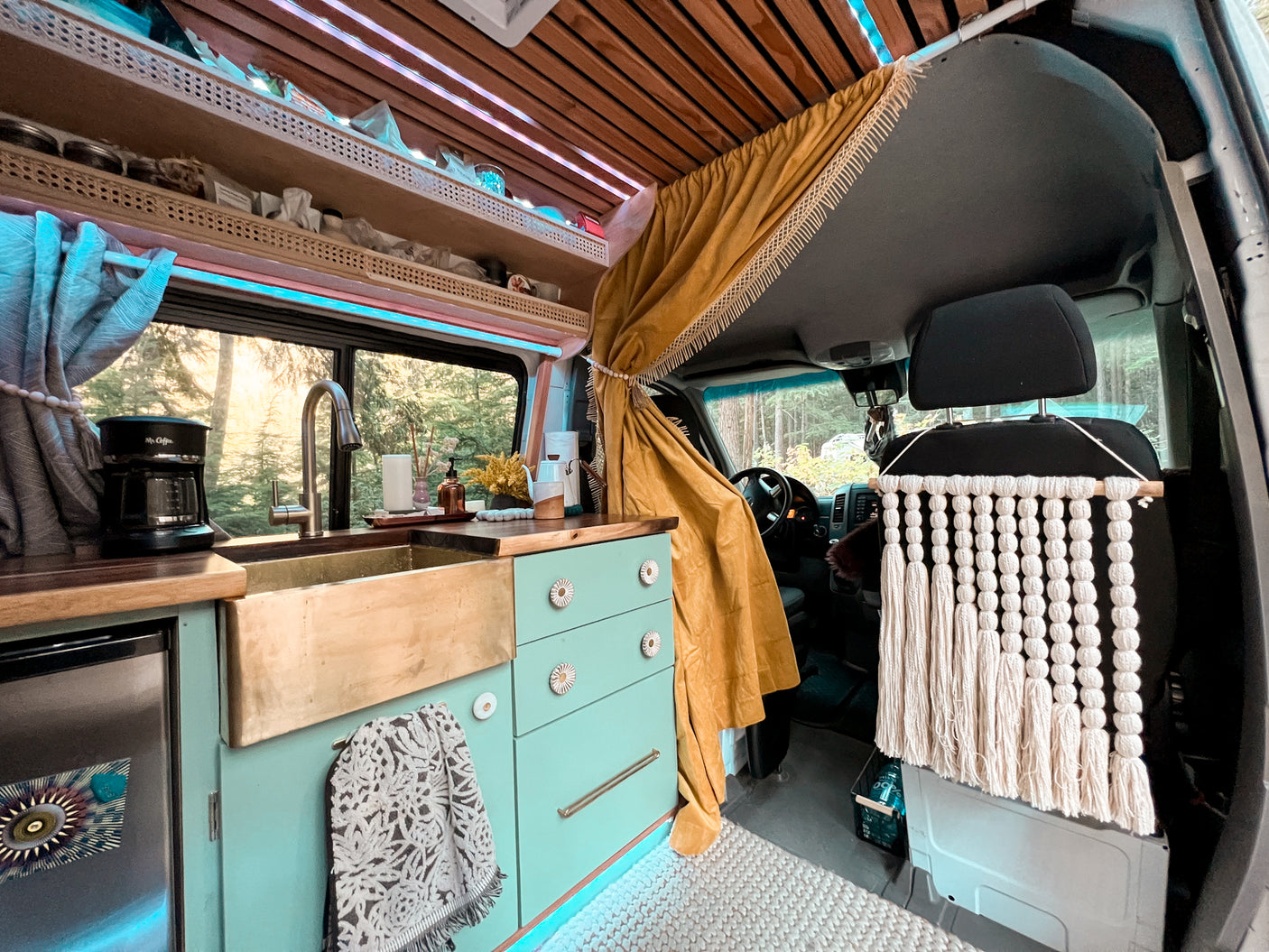 Step into this custom RV rental, featuring a serene kitchen, wood ceilings, and cozy details for your road trip.