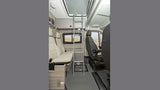 Interior of an RV rental: comfortable seating, overhead bunk with ladder, and compact design perfect for travel adventures.