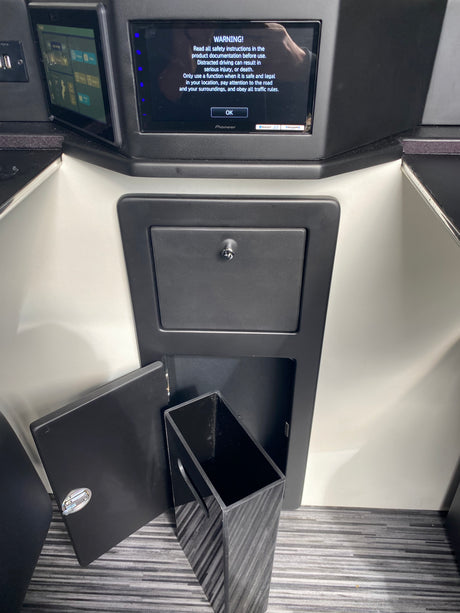 RV rental interior showing a Pioneer infotainment screen warning, control panel, and handy pull-out trash bin storage.