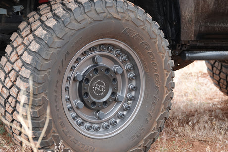 Close-up of a dirt-covered BFGoodrich Mud-Terrain tire on a Black Rhino wheel, ready for your RV rental adventure.