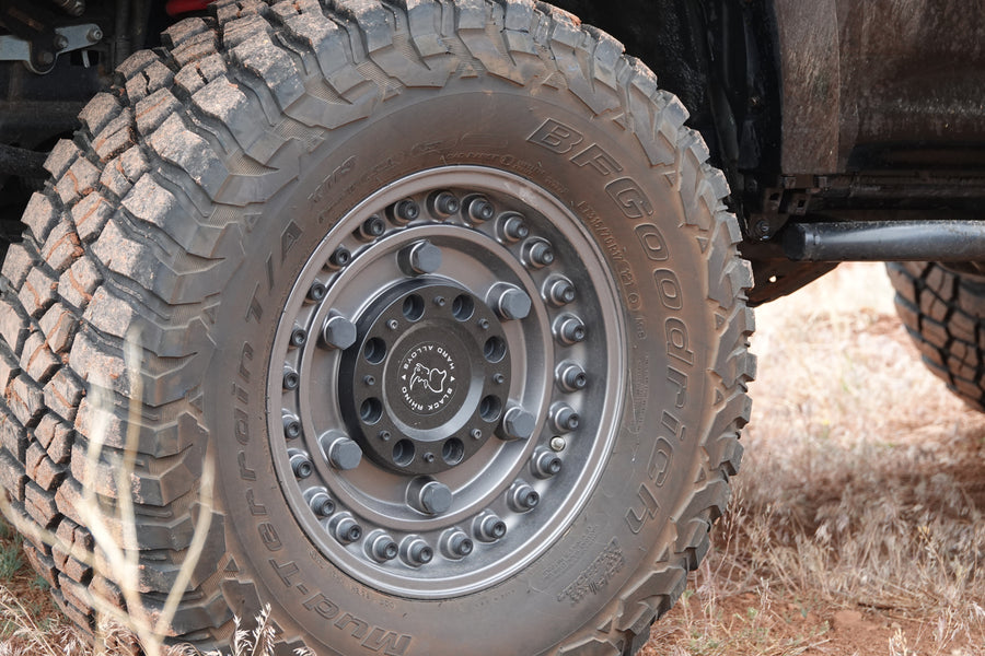 Close-up of a dirt-covered BFGoodrich Mud-Terrain tire on a Black Rhino wheel, ready for your RV rental adventure.
