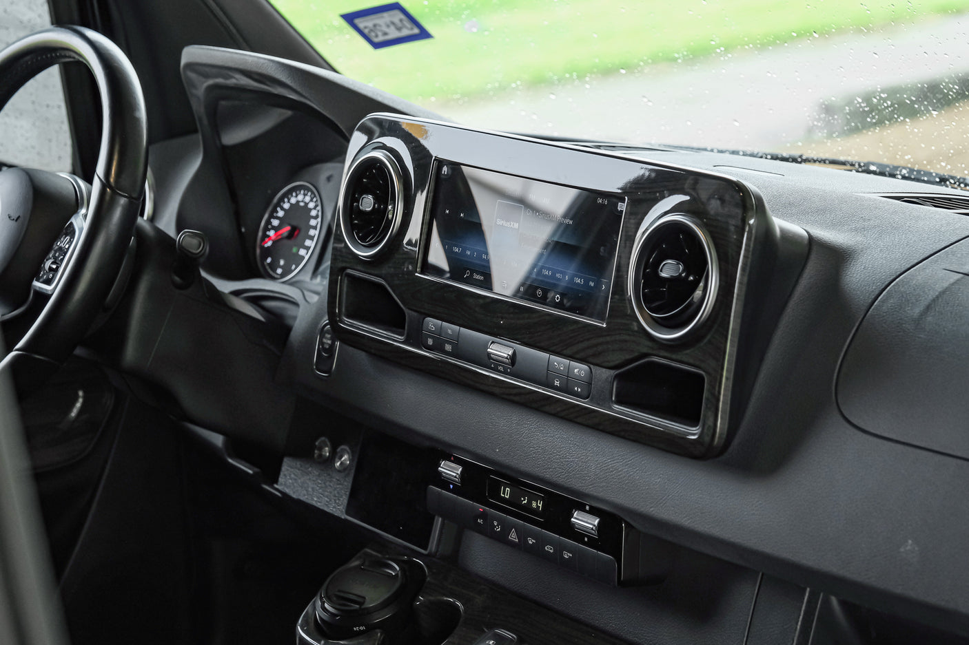 RV rental interior dashboard: Modern design with a multi-function steering wheel, infotainment screen (SiriusXM), and climate controls.