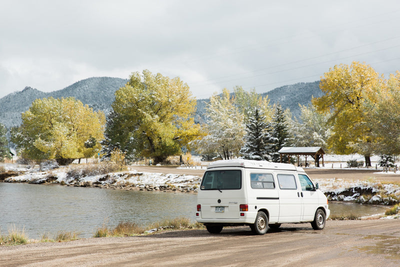 White camper van, an ideal RV rental, parked lakeside amidst snowy autumn mountains and golden trees. — photo 15