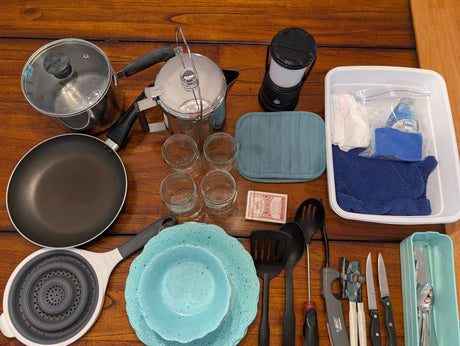 Essential RV rental kitchen kit: cookware, dishes, cutlery, cooking tools, lantern, & cleaning supplies for your road trip comfort.