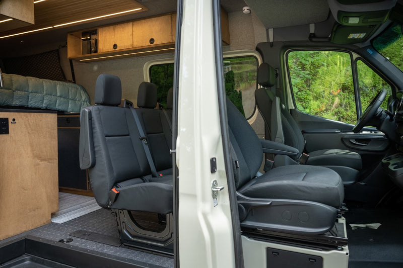 Interior of an RV rental: a modern camper van conversion with a bed, passenger seats, and front cockpit. Perfect for trips. — photo 6