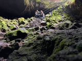 Family enjoying a mossy cave entrance, a perfect stop for your next RV rental adventure.
