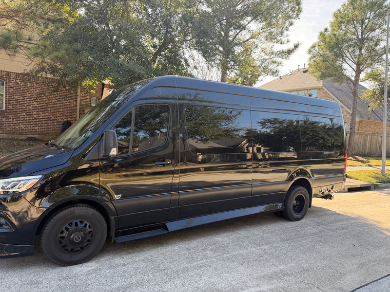 Black Mercedes-Benz Sprinter RV rental, "Ultimate Coach" branded, parked on concrete on a sunny day. — photo 1