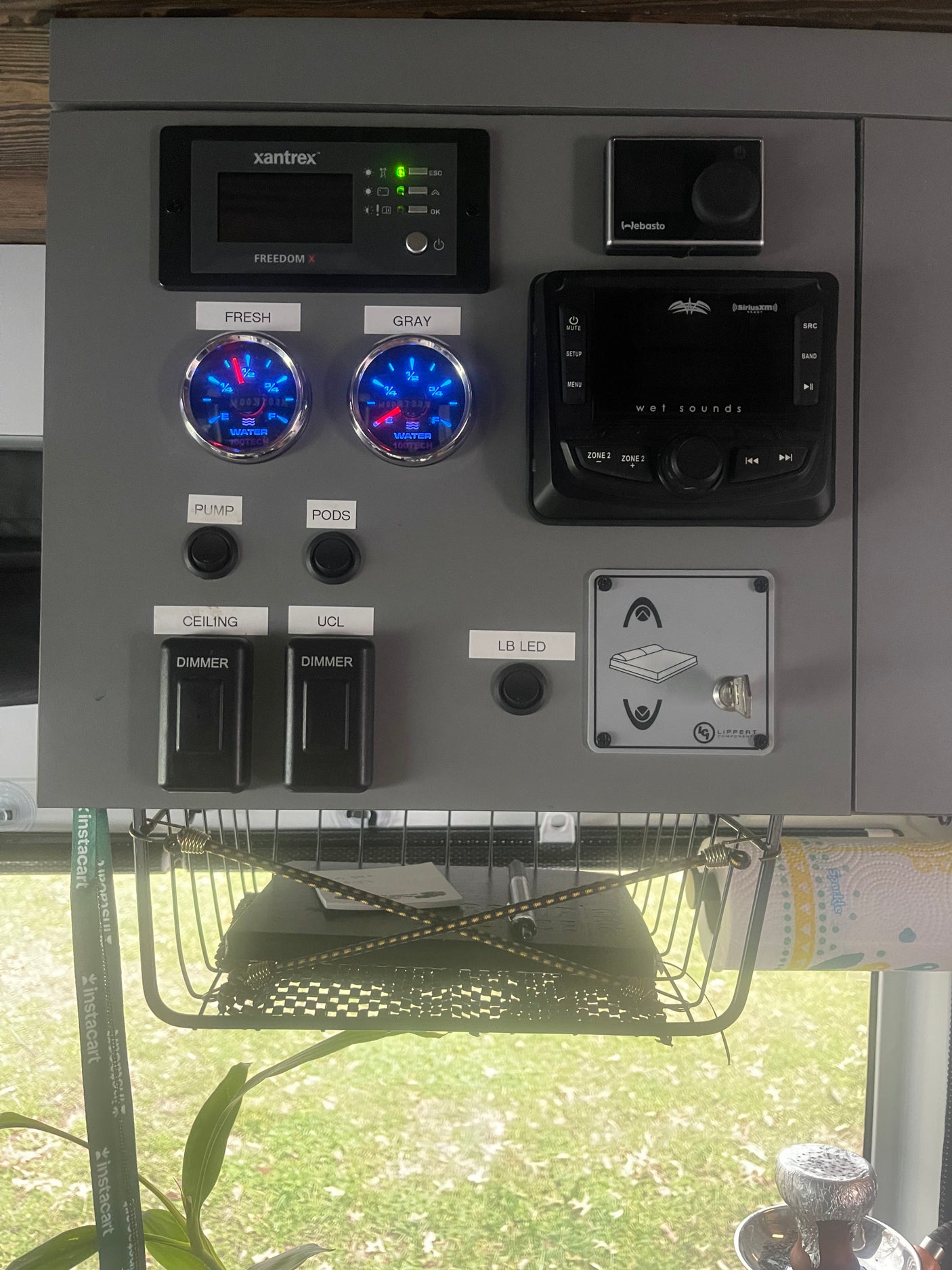This RV rental control panel features water level gauges, a power inverter, audio system, heating, and bed lift controls.