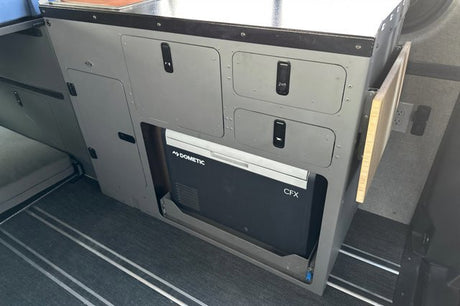 RV rental interior: Dometic CFX fridge on slide-out, modular cabinets, and fold-down table for adventure.