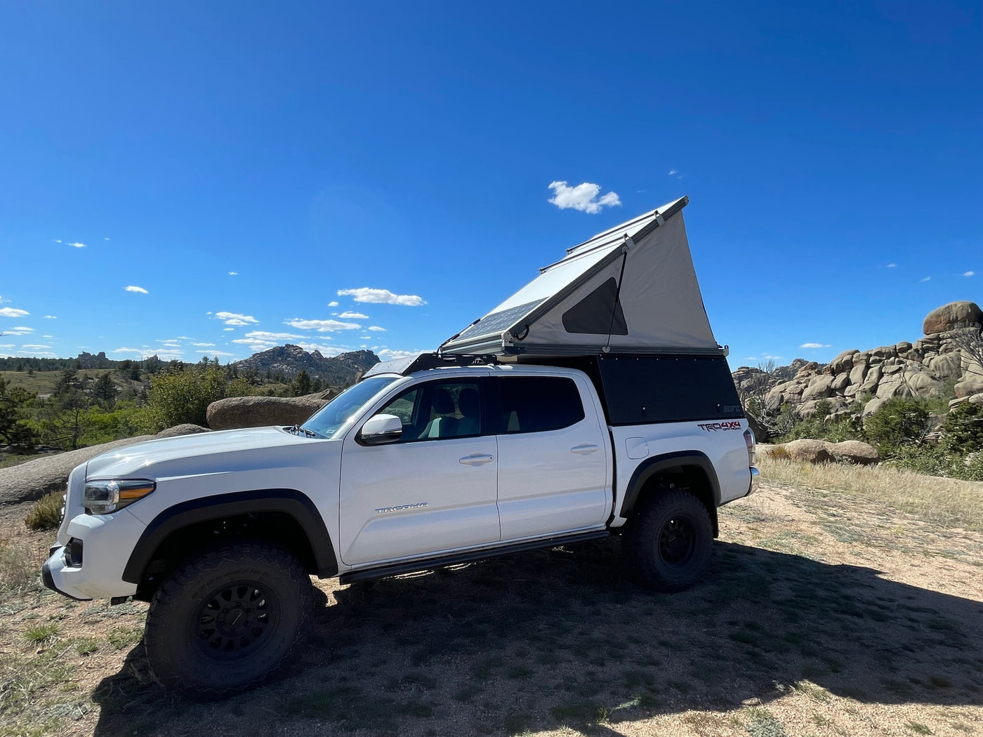 White Toyota Tacoma truck with pop-top camper ready for adventure. Perfect as an off-grid RV rental for exploring rugged terrain. — photo 9