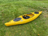 Yellow kayak on green grass. Get ready for water adventures with your RV rental, perfect for outdoor trips!