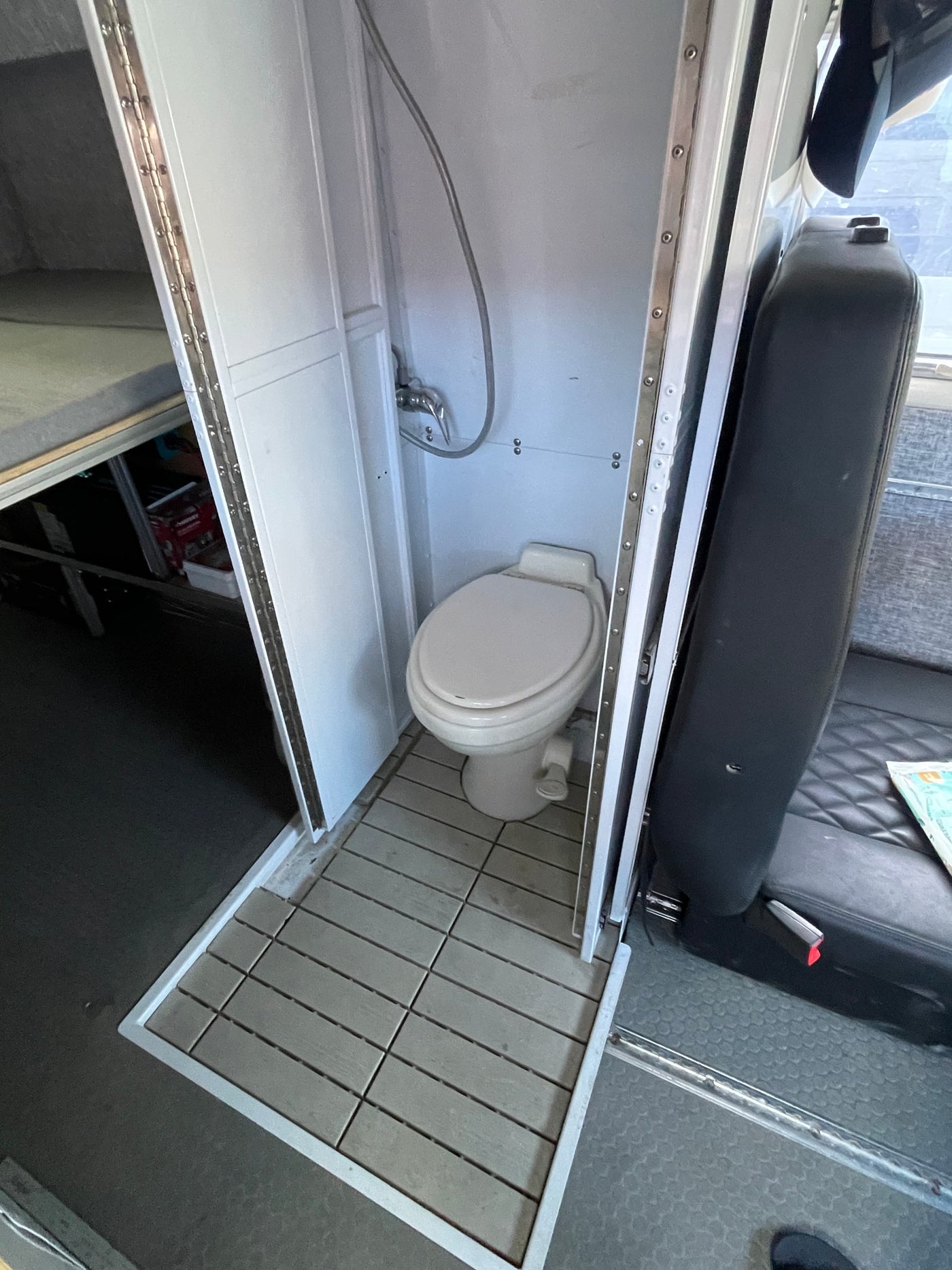  parked on concrete under a cloudy sky.|RV rental interior featuring practical overhead storage — photo 6