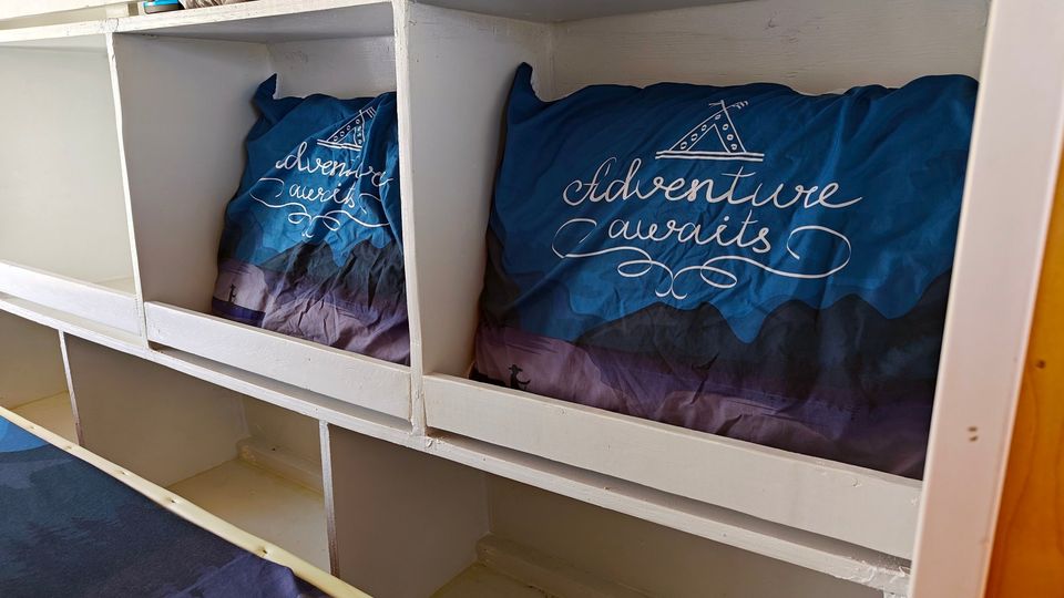  and scenic outdoor views.|Adventure awaits in this cozy RV rental bed. Van interior with view of street — photo 9
