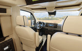 Luxurious rv rental interior with cream captain's chairs, modern dashboard, and a scenic road view. Ideal for travel.