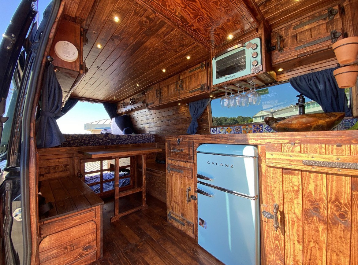  and dining. Ideal for van life.|This RV rental offers a custom wood interior with bunk beds — photo 5