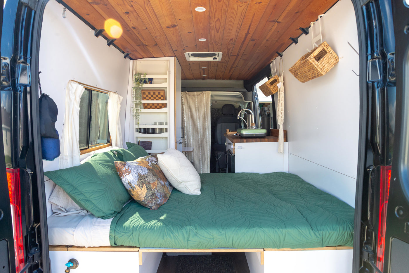 Inside a stylish RV rental camper van: A comfy bed, compact kitchen, and clever storage solutions for mobile living. — photo 4