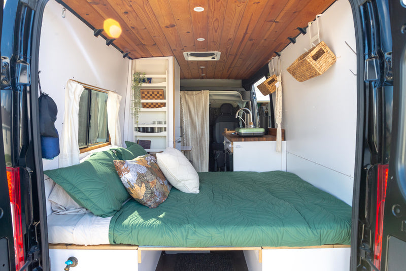 Inside a stylish RV rental camper van: A comfy bed, compact kitchen, and clever storage solutions for mobile living. — photo 4