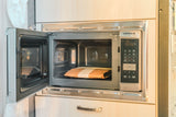 An open CONTOURE microwave with a food pouch in an rv rental, offering convenient cooking in a compact kitchen.