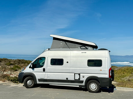 RV rental pop-top camper van parked seaside, offering epic van life views of the ocean. Perfect for outdoor adventures.