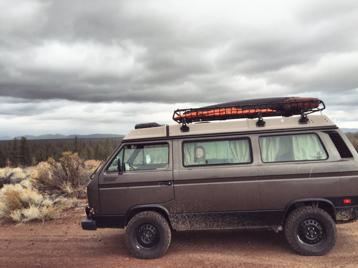  perfect for adventure. A person smiles from inside.|Experience the outdoors with an RV rental! Two VW Westfalia camper vans are set up in a scenic — photo 2