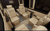 Step into a luxury RV rental featuring plush beige leather seats with diamond quilting, wood accents, and entertainment.