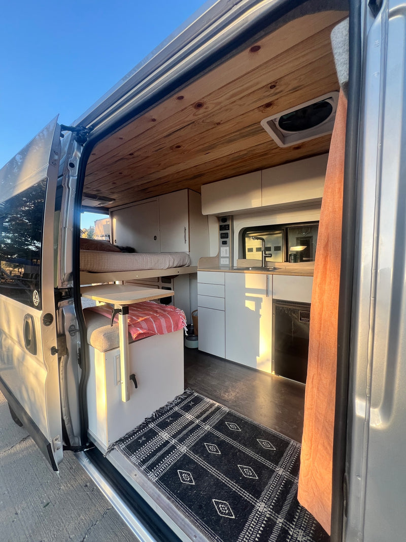 Spacious custom camper van interior, perfect for your next RV rental, with a built-in kitchen, bed, and cozy decor. — photo 6