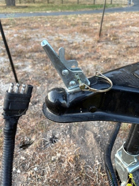 RV rental: Trailer hitch coupler with safety pin and electrical plug for safe connection.