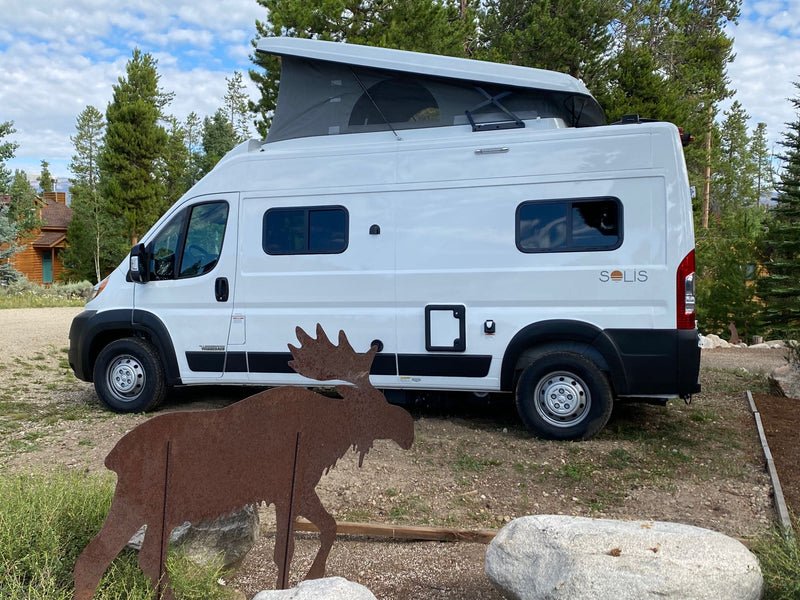  surrounded by trees and mountains.|White Winnebago Solis camper van — photo 2