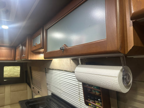 RV rental kitchen: wooden cabinets with frosted glass, paper towel holder, and spice rack for compact travel.