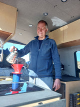 Enjoying morning coffee in a modern RV rental, embracing the van life adventure.