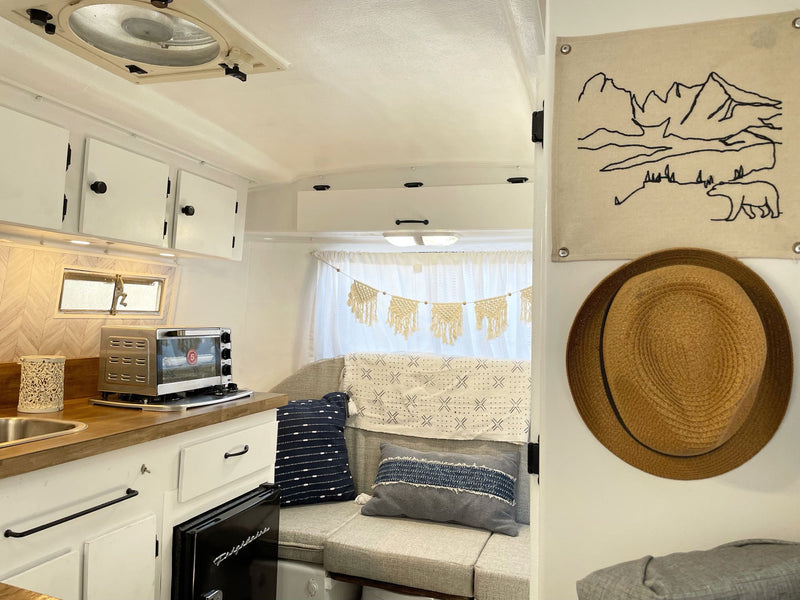 and clean design.|Cozy RV rental interior featuring a compact kitchen with kettle — photo 7