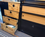 RV rental campervan with bamboo drawers & black cabinets. Open drawers show kitchen storage, perfect for mobile travel.